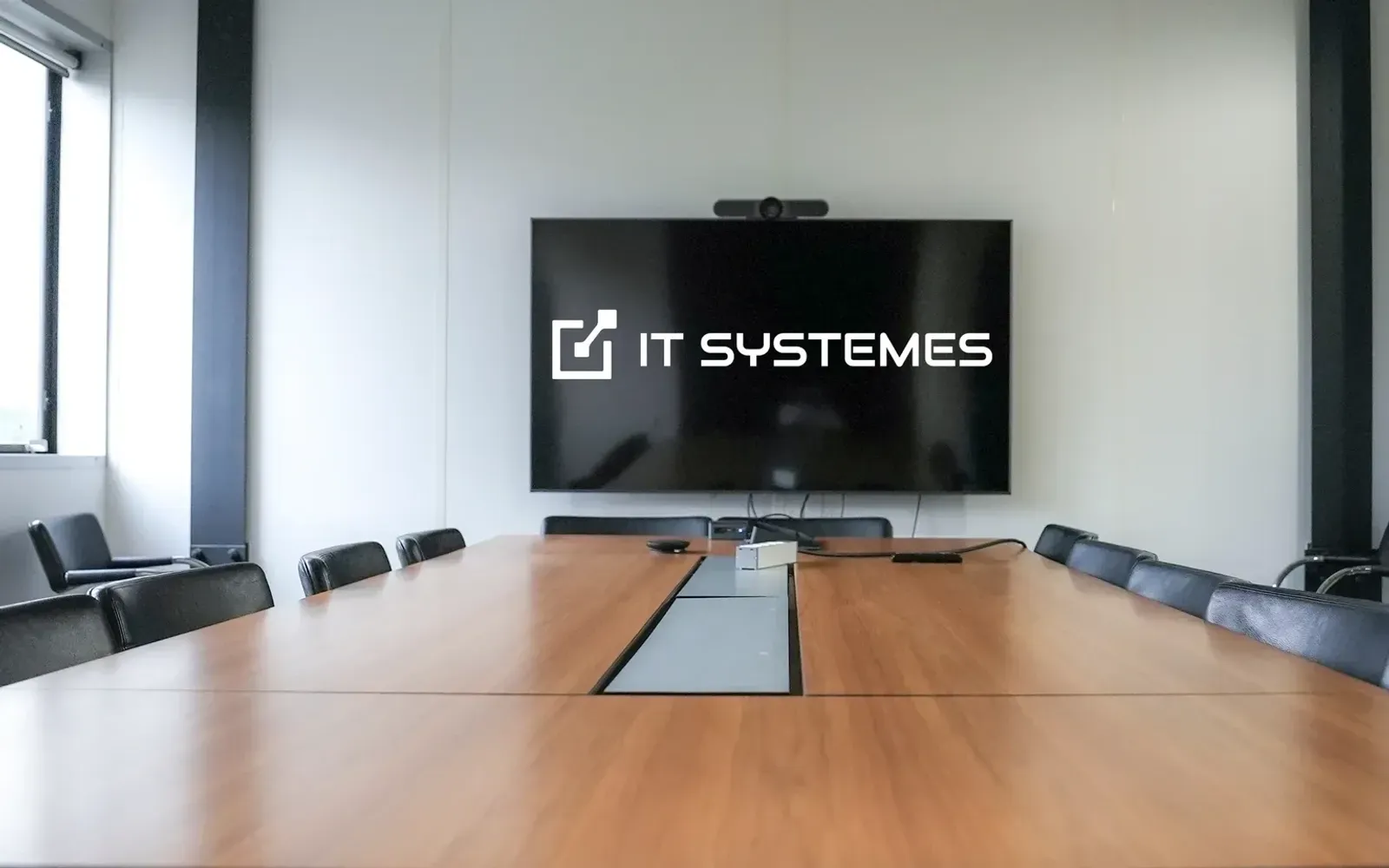 Salle de réunion d'IT Systèmes, logo de l'entreprise à l'écran
